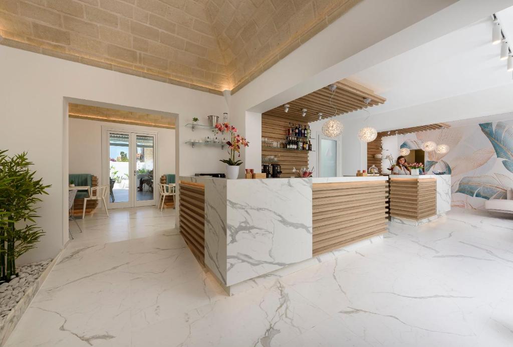 a kitchen with a counter and a living room at Andromeda Hotel in San Vito lo Capo