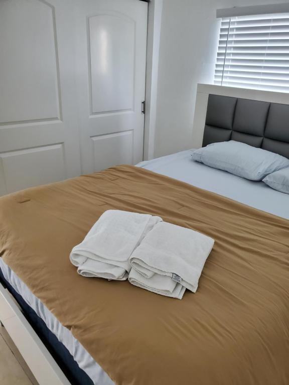 a bed with two white towels on top of it at 1161 Studio 2 Miami in Tamiami