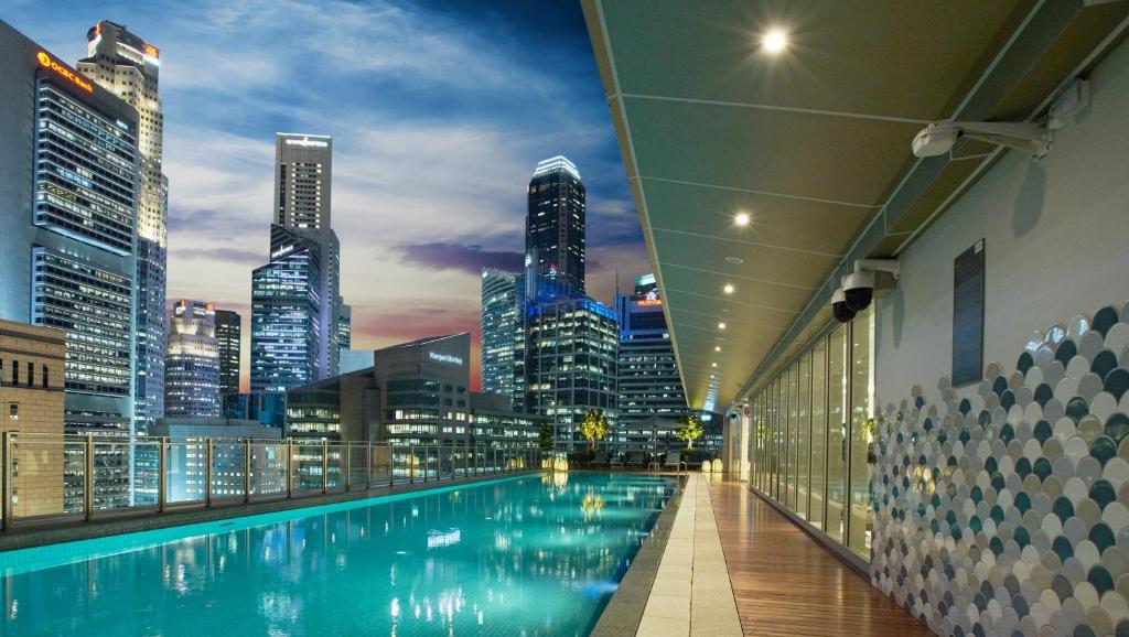 a swimming pool in a building with a city skyline at Capri by Fraser China Square, Singapore in Singapore