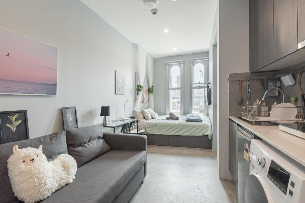 un soggiorno con un divano e una camera da letto di Modern Double Studio Room - AC - 1Mins to Central - Nearby Most Sydney Hotspots a Sydney