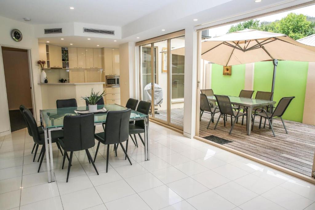 a dining room with a table and chairs and an umbrella at Wood Peak in Bright