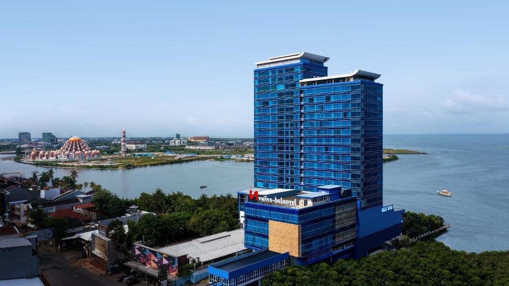 an aerial view of a tall building next to the water at Swiss-Belhotel Makassar in Makassar
