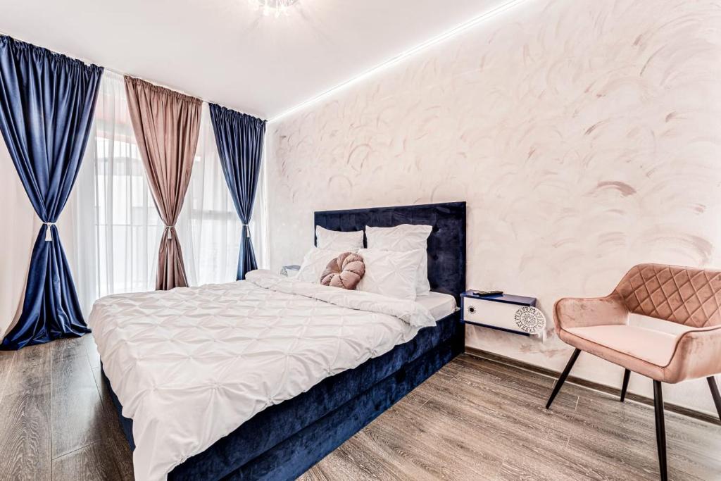 um quarto com uma cama e uma cadeira em ARI Rose Apartment in complexul Ared Kaufland em Arad