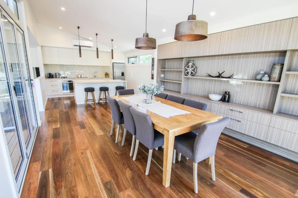 a kitchen and dining room with a wooden table and chairs at Villa Urbane in Bright
