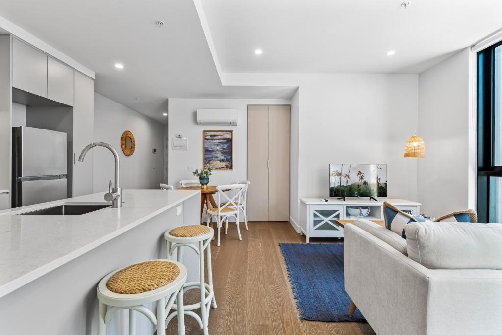 kuchnia i salon z kanapą i stołem w obiekcie Elegant 1-Bed by Shops with Rooftop Swimming Pool w Melbourne