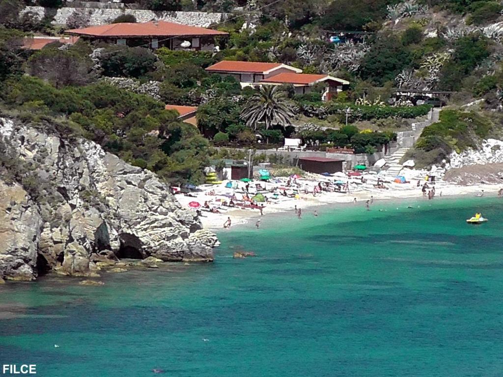 a beach with a bunch of people in the water at Residence Capobianco in Portoferraio