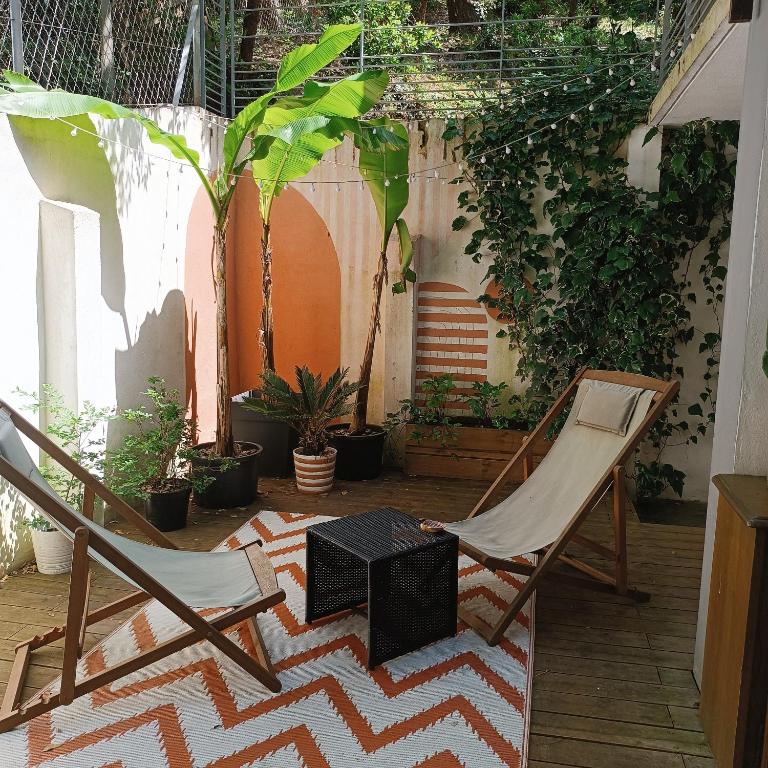 une paire de chaises et une table sur une terrasse dans l'établissement HOSSEGOR LE GARDEN lac et océan à pieds, à Soorts-Hossegor