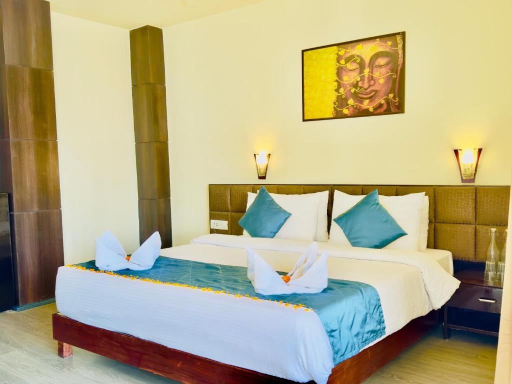 - une chambre avec un grand lit blanc et des oreillers bleus dans l'établissement Staynest Tara with mountain valley view near MALL ROAD, à Gangtok