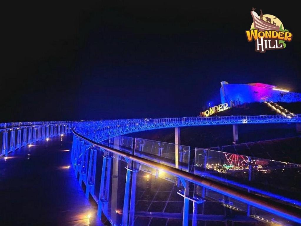 a bridge over the water at night with a sign at Novaworld Phan Thiết-7Days mart in Phan Thiet