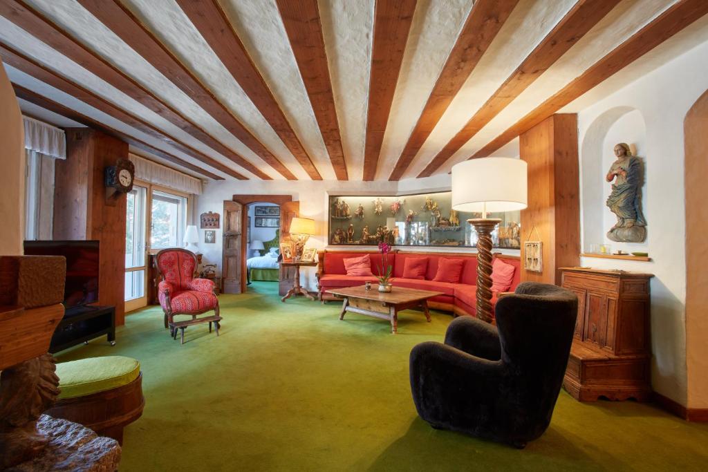 sala de estar con sofá rojo y sillas en Lioda Castle, en Cortina dʼAmpezzo