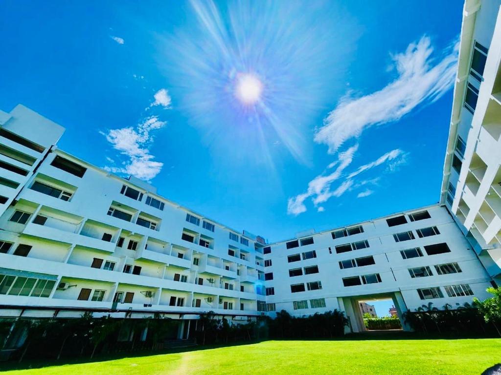 a white apartment building with a blue sky in the background at Seven Hills Hotel in Puri