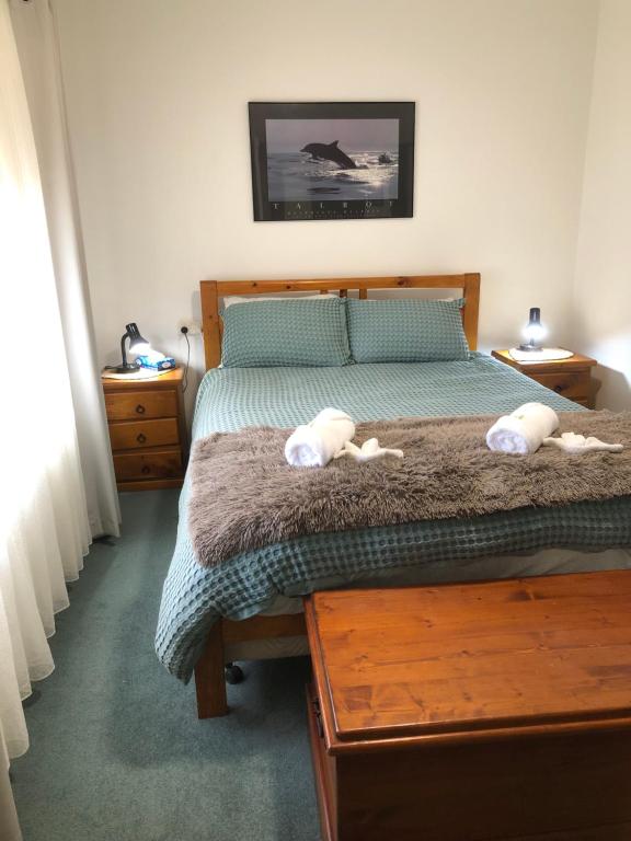a bedroom with a bed with two stuffed animals on it at Strangways Villa in Mount Gambier