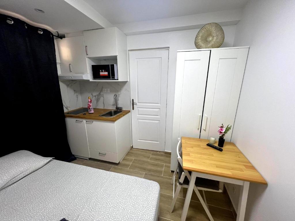Cette petite chambre comprend un lit, une table et une cuisine. dans l'établissement Villa Paradis Étoilé luxe & 4, à Nice