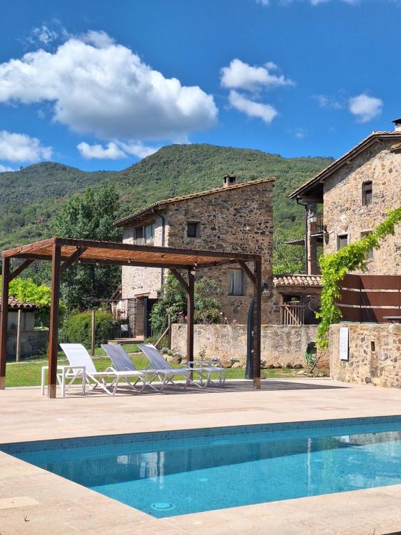 einen Pool mit zwei Liegestühlen und ein Haus in der Unterkunft El Niu Casa Rural in Montagut
