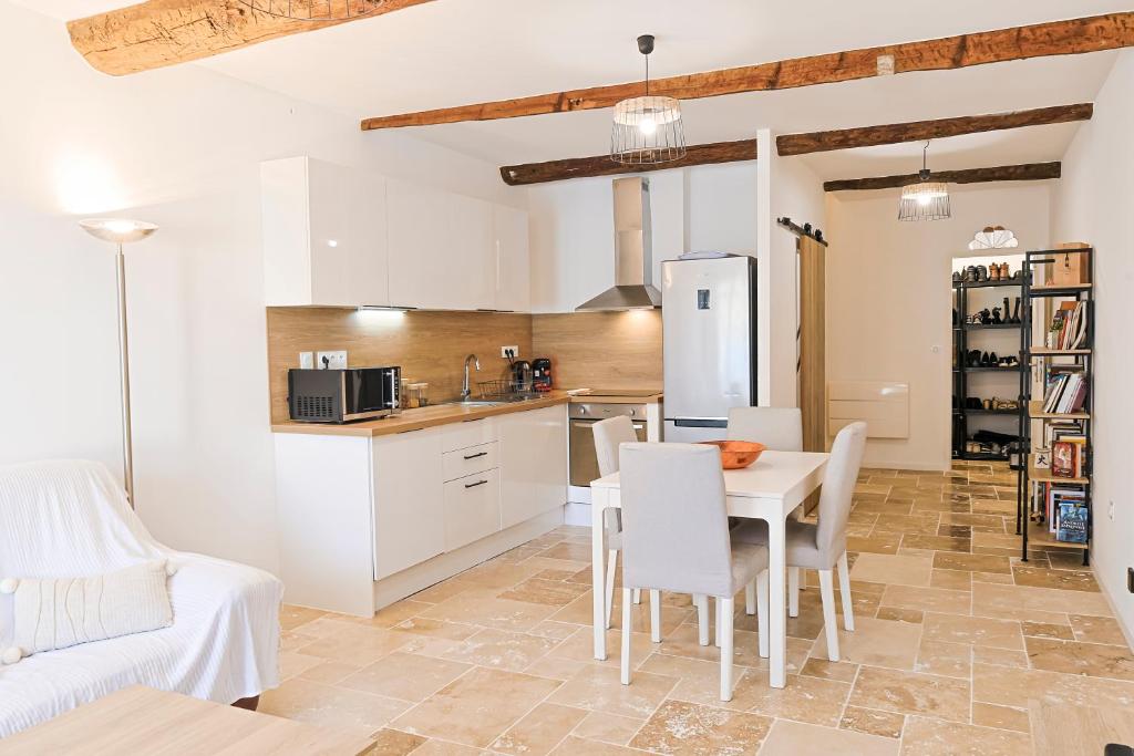 une cuisine et une salle à manger avec une table et des chaises dans l'établissement Maison T3 2CH - Les Volets Bleus, à Lapalme