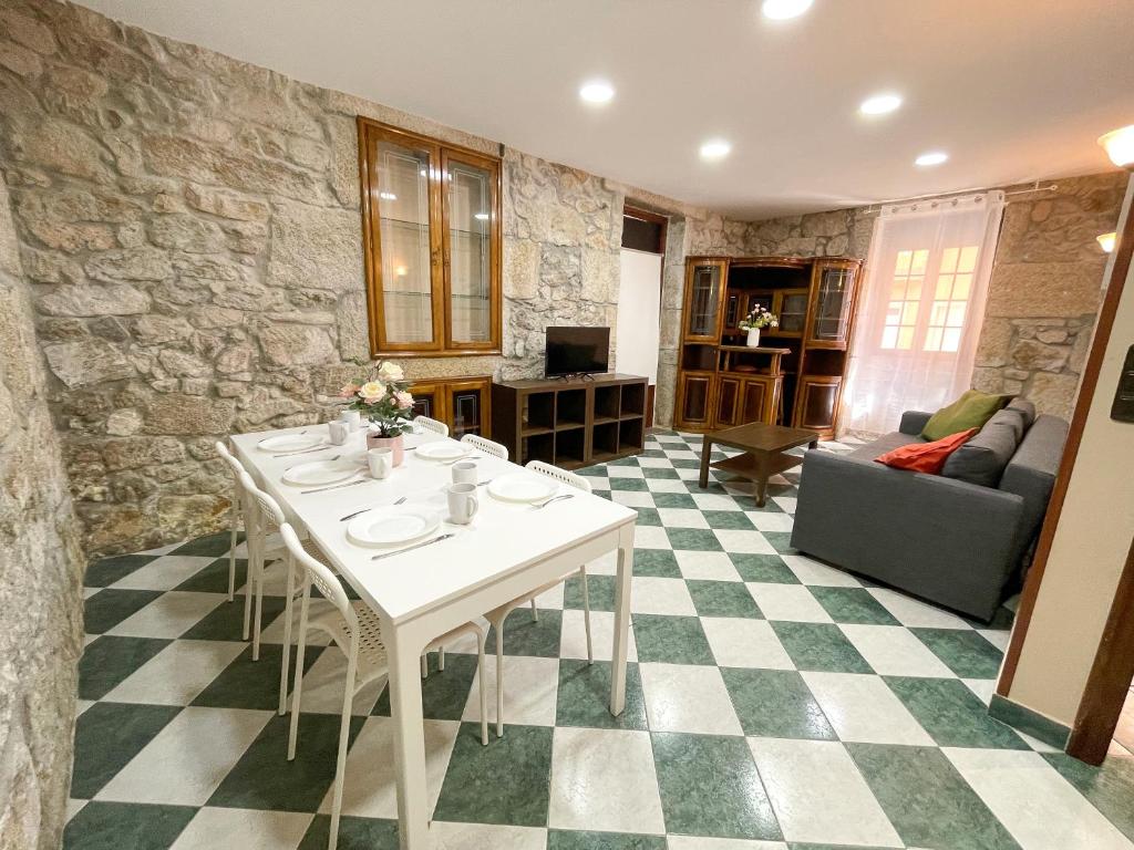 a living room with a table and a stone wall at Apartamentos Illa de Arousa Centro 3000 in Isla de Arosa