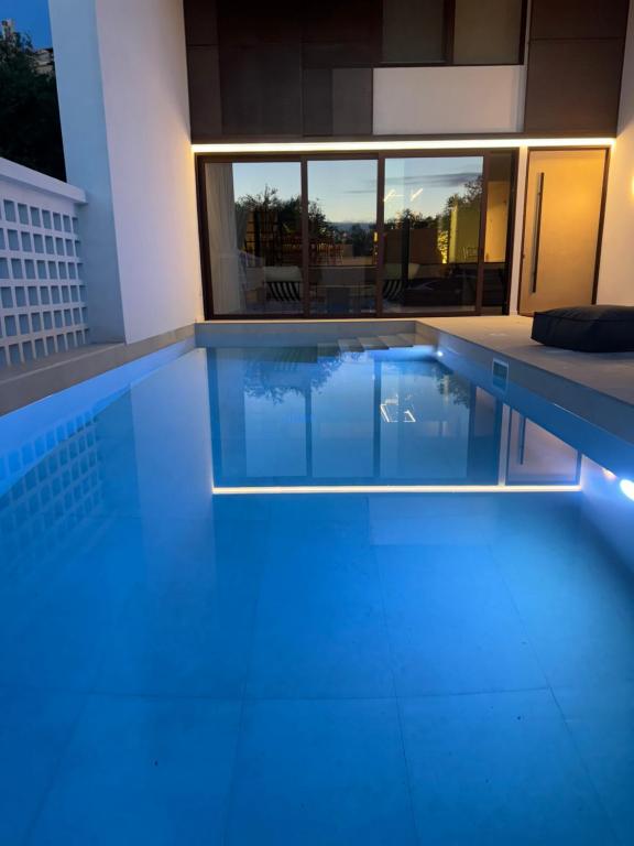una piscina con iluminación azul en una casa en Habitals villa, en Sivota