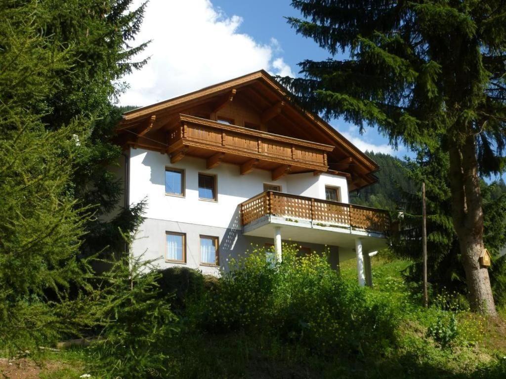 a large white house with a wooden balcony at Bergadler in Iselsberg