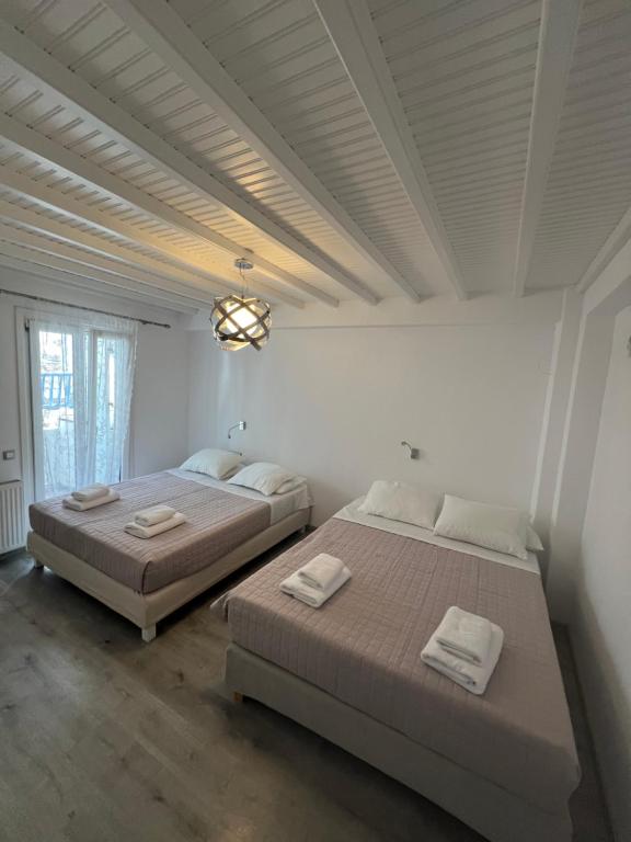 2 Betten in einem weißen Zimmer mit einer Decke in der Unterkunft Beautiful apartment in Mykonos town ! in Mykonos Stadt