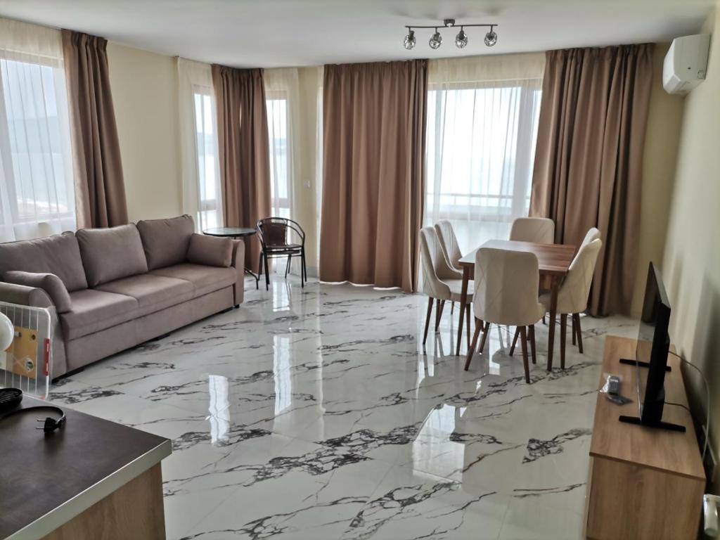 a living room with a couch and a table at Zigrabay lovely appartments in Primorsko