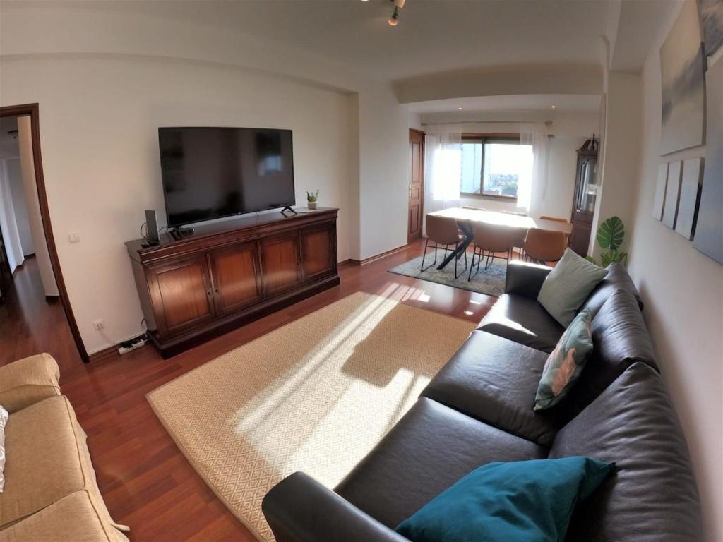 a living room with a couch and a flat screen tv at Lisbon T2 apartment in condominium in Linda-a-Velha Oeiras Lisbon in Linda-a-Velha
