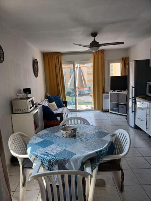 un salon avec une table et des chaises et une cuisine dans l'établissement T2 climatisé front de mer avec terrasse et parking - V0742, à Vias