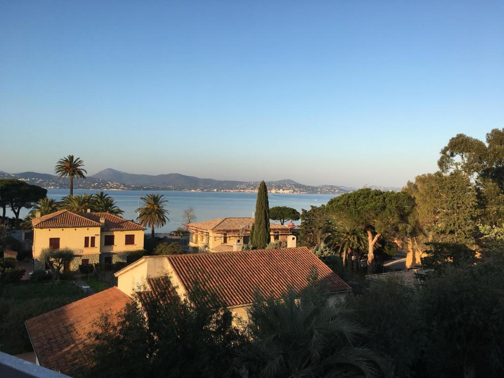 - une vue sur une maison avec un lac en arrière-plan dans l'établissement Terrasse vue mer, Saint-Tropez, à Saint-Tropez