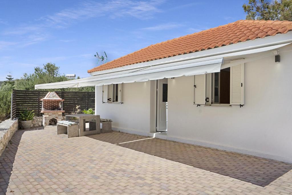 a white house with a red roof and a patio at Casa Della Nonna in Argostoli