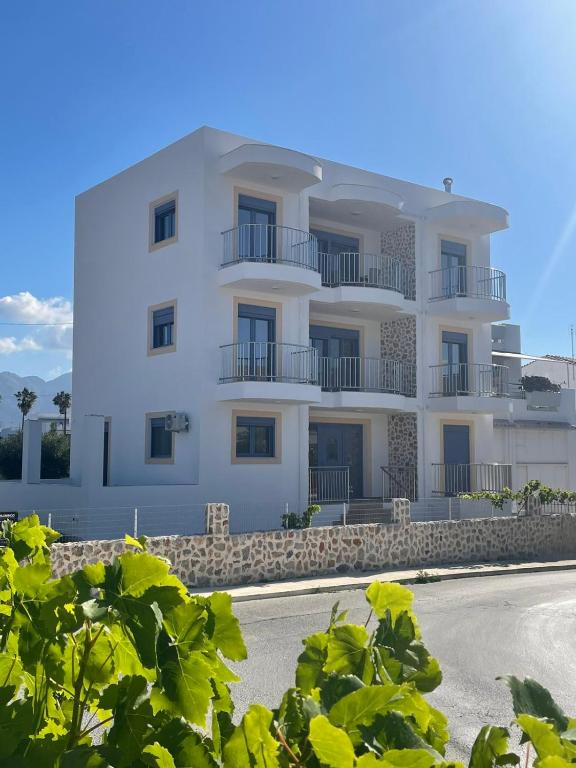 a white building with balconies on the side of it at PARASCHOS APARTMENTS Kardamaina in Kos