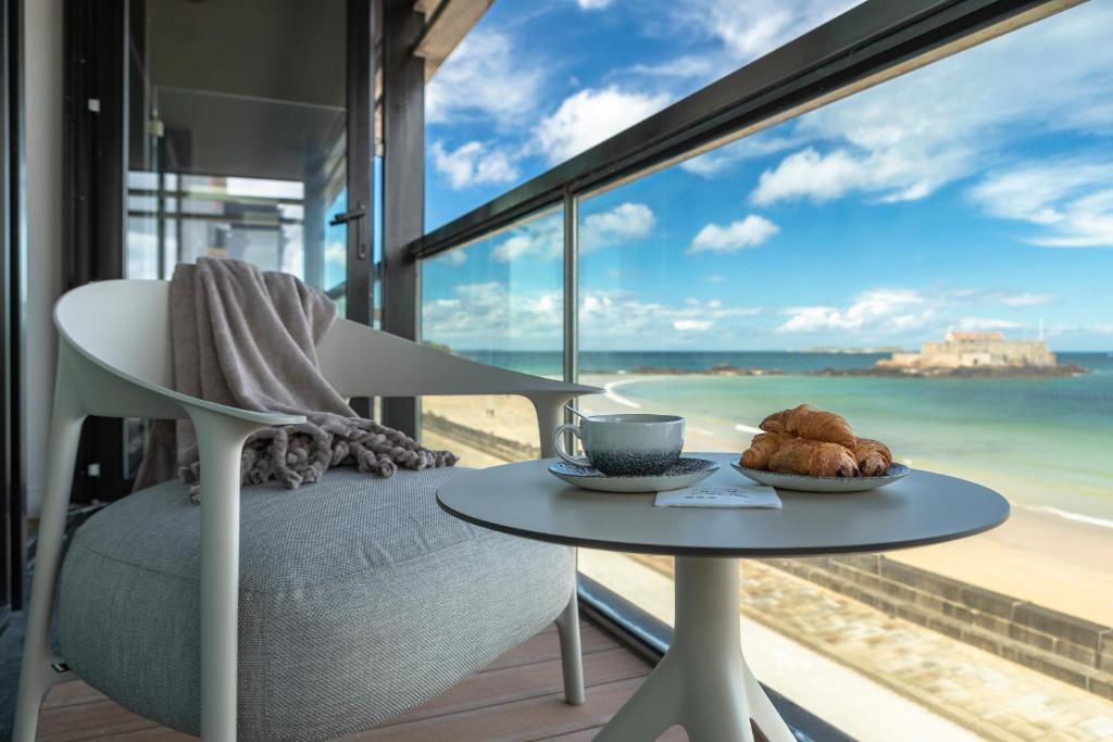 - une table avec une tasse de café et un plateau de croissants dans l'établissement Oceania Saint Malo, à Saint-Malo