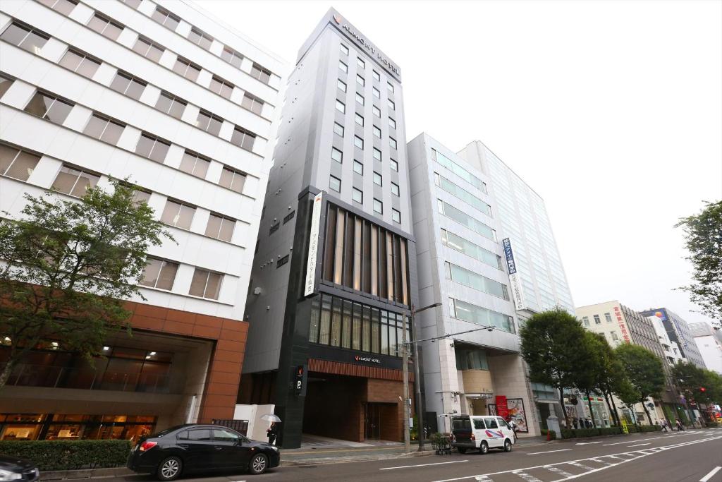 un edificio en una calle de la ciudad con coches aparcados delante en Almont Hotel Sendai en Sendai