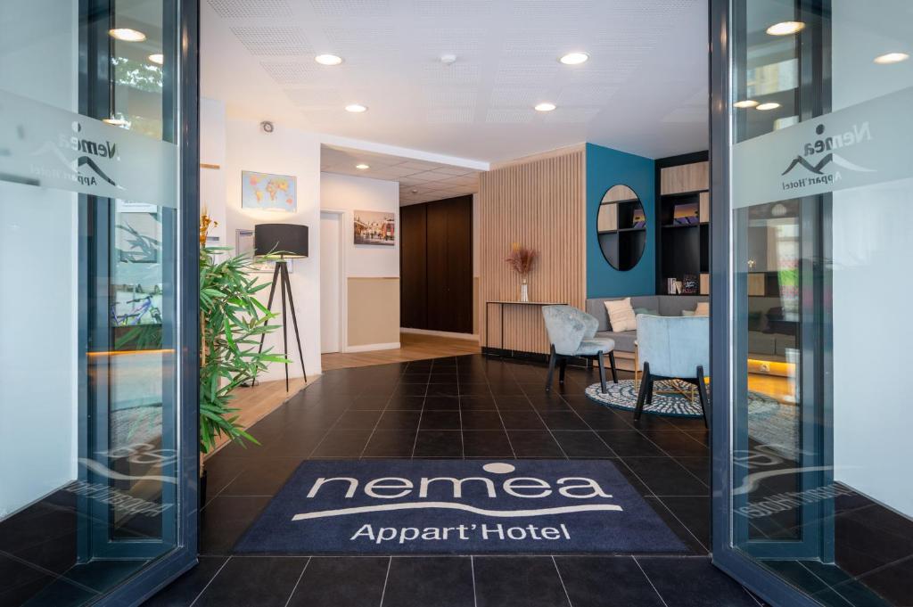 una entrada a una oficina con una casa de agentes narrados en Nemea Appart Hotel Home Suite Nancy Centre en Nancy