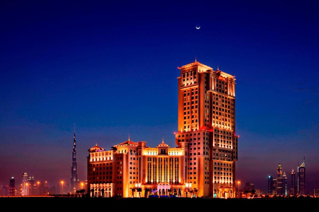 a tall building with lights on it at night at Marriott Executive Apartments Al Jaddaf, Dubai in Dubai