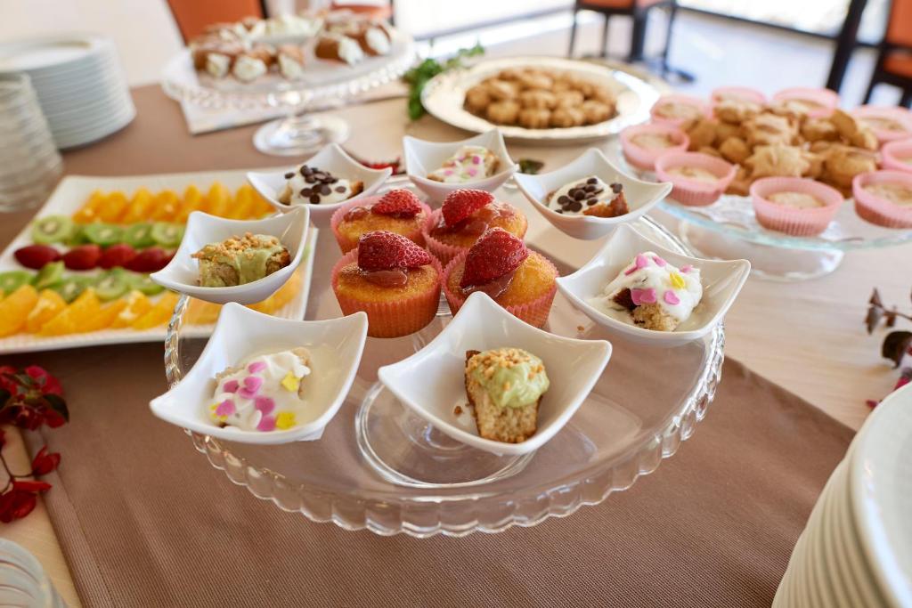 a table with a plate of cupcakes and other desserts at Baglio Dello Zingaro in Scopello