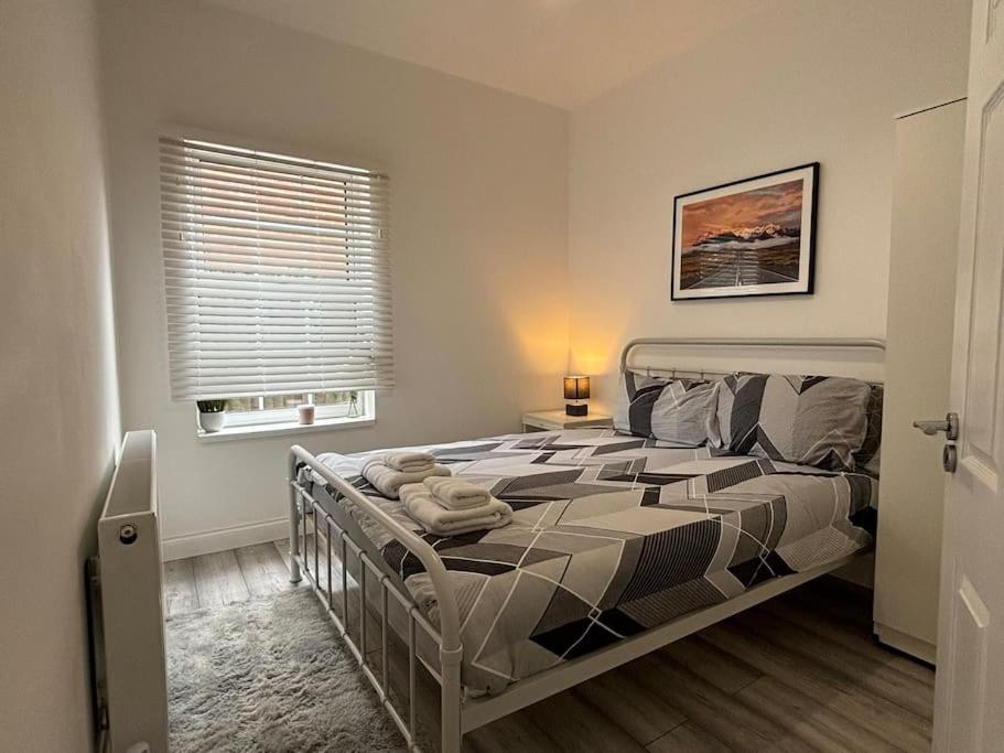 1 dormitorio con cama y ventana en Charming 2BR Cottage - Fully Furnished - 10min LGW - Free Parking, en Crawley
