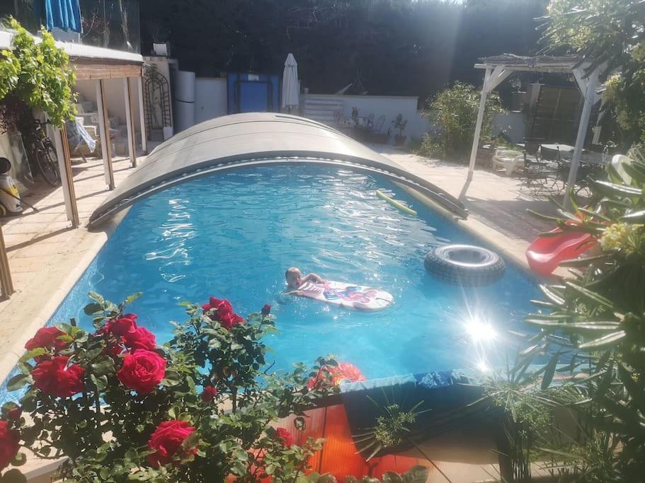 une personne nageant dans une piscine avec un radeau dans l'établissement Studio indépendant dans villa avec piscine Cagnes, à Cagnes-sur-Mer