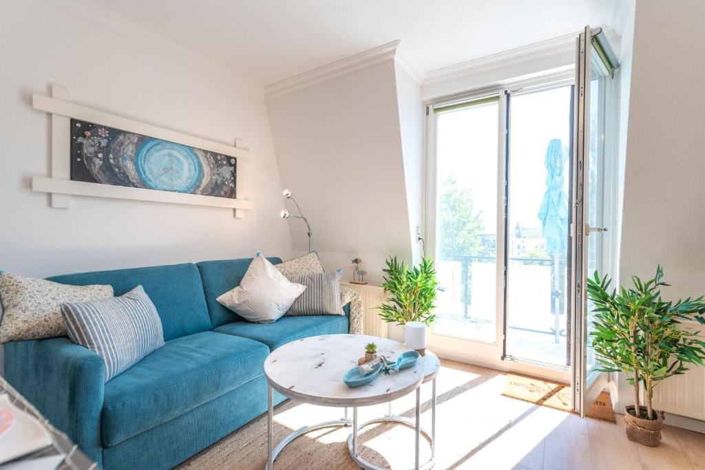a living room with a blue couch and a table at Ostseesuite Bansin in Bansin