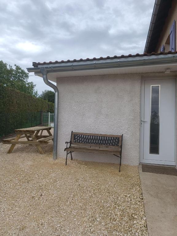 un banc et une table de pique-nique à côté d'un bâtiment dans l'établissement le petit cocon, à Montbozon