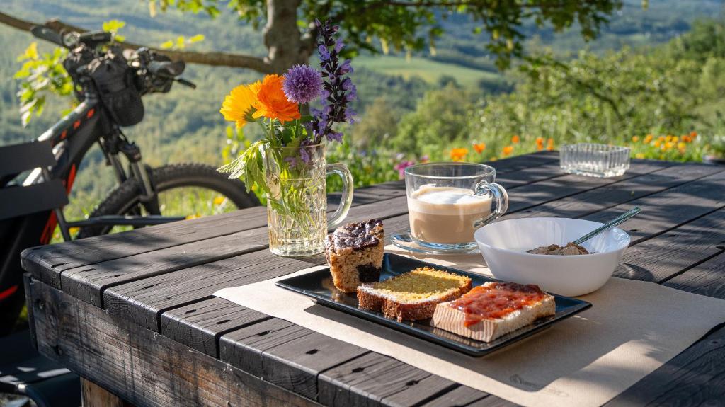 a table with a plate of bread and coffee and flowers at Le Spine B&B sulla Via Francigena in Berceto