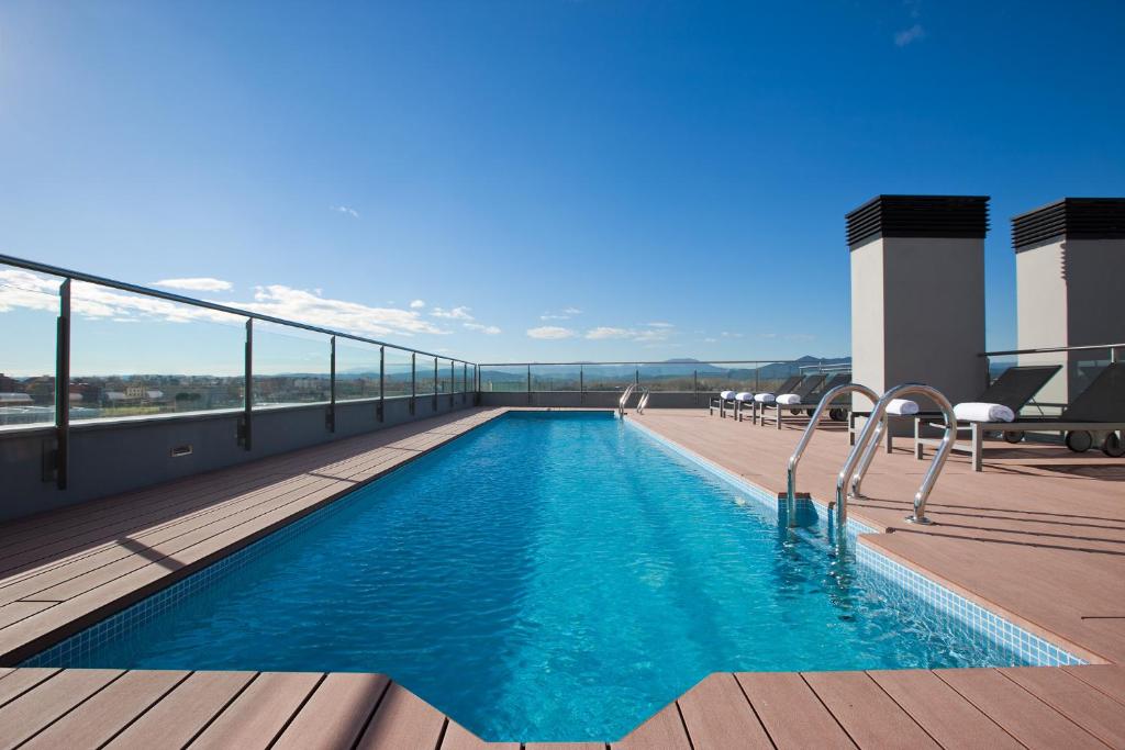 una piscina en la azotea de un edificio en DoubleTree by Hilton Girona, en Girona