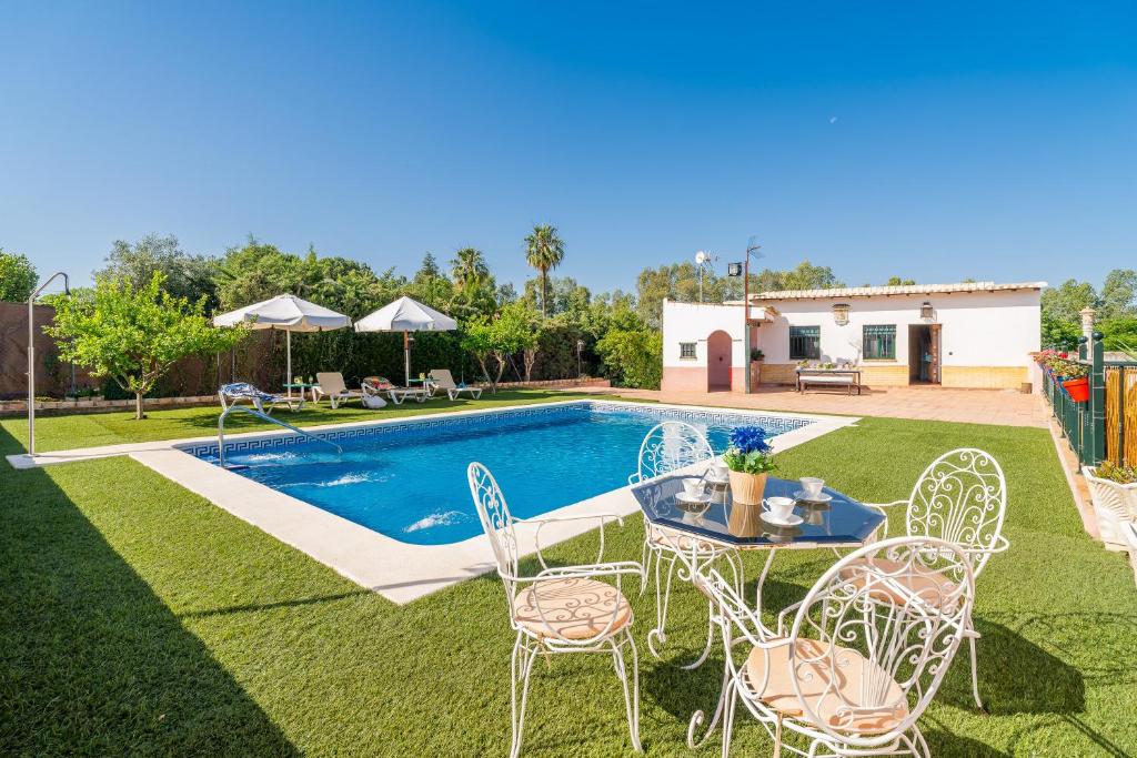 a backyard with a table and chairs and a pool at Casa Rural Carmo in Carmona