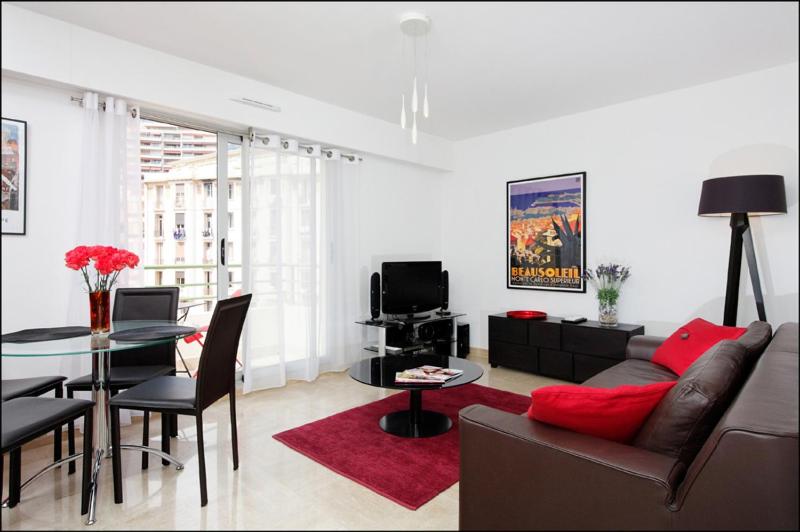 un salon avec un canapé et une table dans l'établissement Sunlight Properties - Bugatti - Beausoleil, France 1 Bedroom, stunning holiday rental apartment with balcony, à Beausoleil