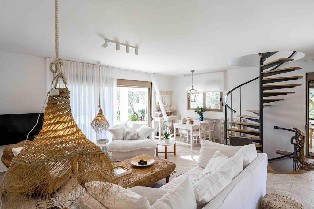 un soggiorno con un divano bianco e un tavolo di Stylish Pool Villa Konstantinidis Complex a Hanioti