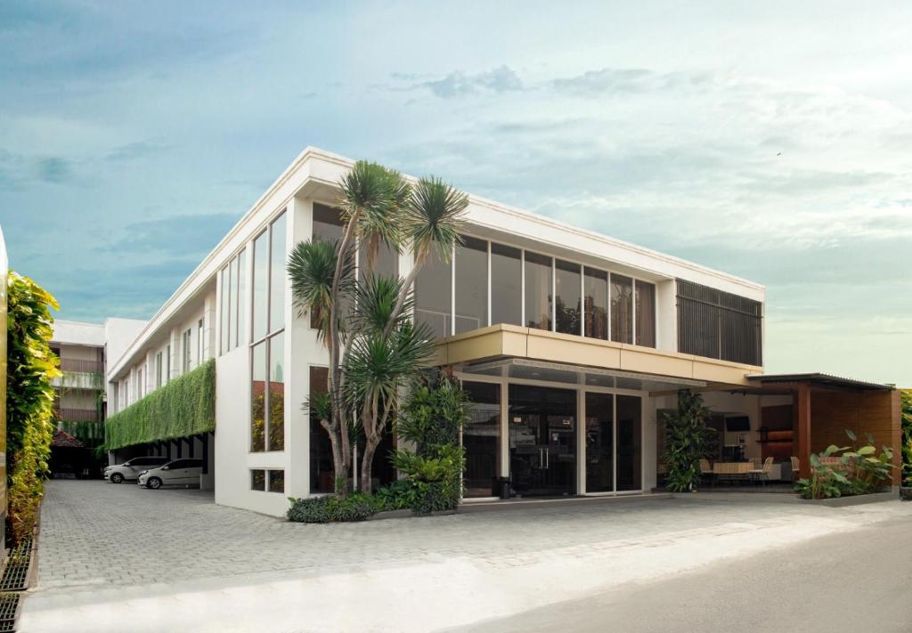 an office building with palm trees in front of it at Aveon Express Hotel by Daphna International in Yogyakarta