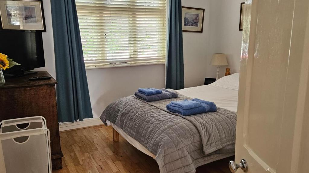 a bedroom with two blue towels on a bed at Old School Apartment 1 First Floor in Bury Saint Edmunds
