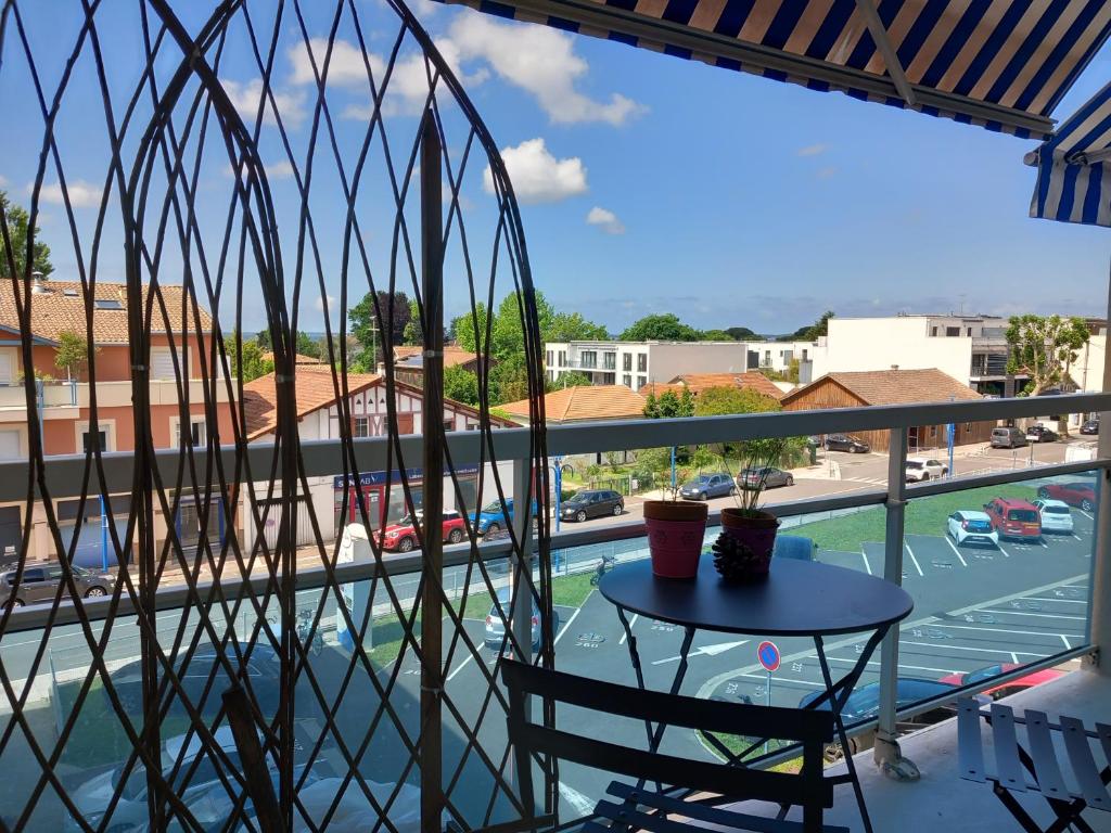d'un balcon avec une table et une vue sur la piscine. dans l'établissement Au cœur du coeur, à Andernos-les-Bains