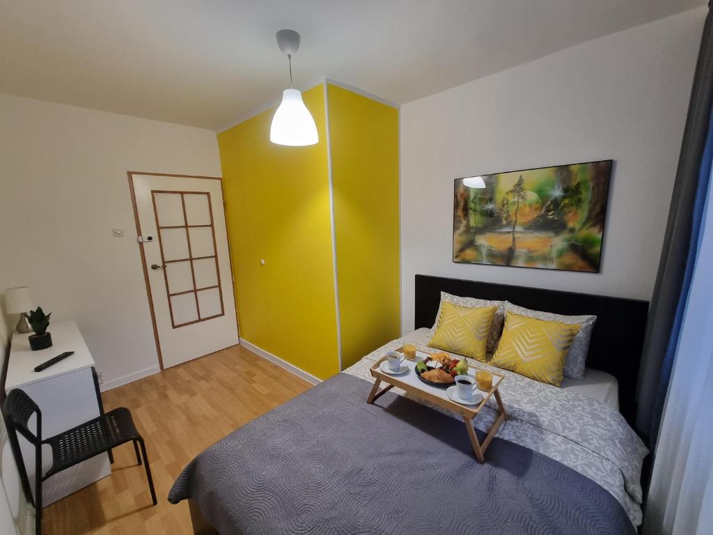 a bedroom with a bed with a tray of fruit on it at Pokoje Częstochowa in Częstochowa