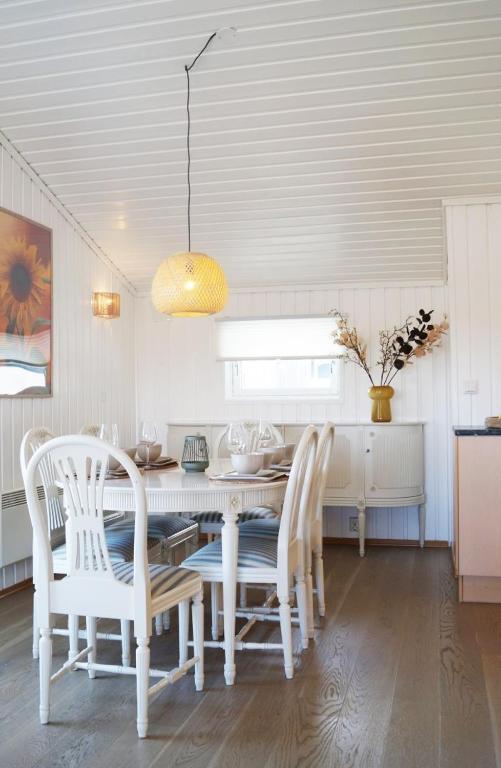 a white dining room with a table and chairs at Sommerstua - Nes Camping in Moss