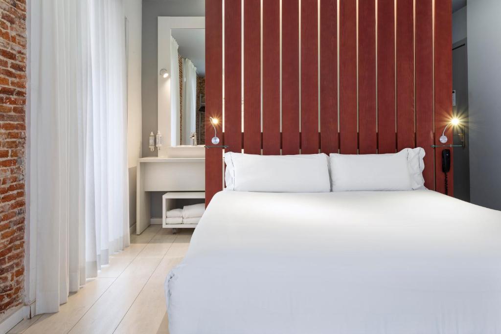 a bedroom with a large bed with a red headboard at B&B HOTEL Madrid Centro Fuencarral 52 in Madrid