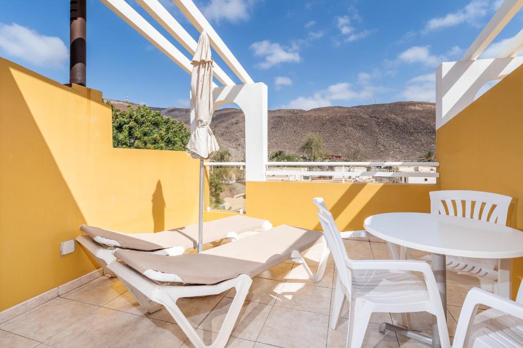 a balcony with a white table and chairs and a view at Apartamentos Punta Marina by LIVVO in Morro del Jable